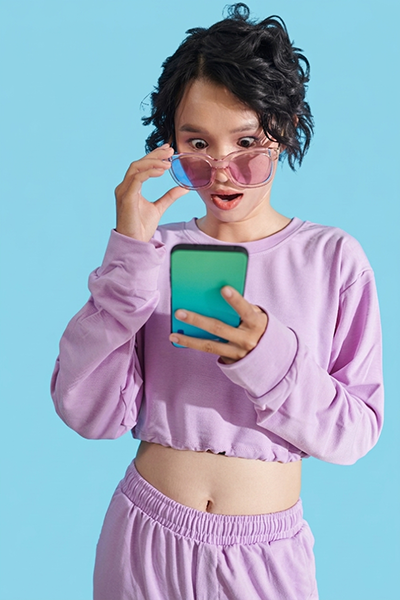 jeune fille surprise en regardant son téléphone