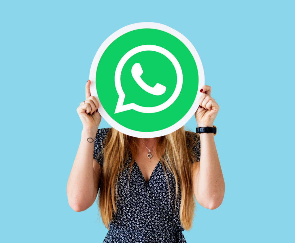 personne tenant un logo WhatsApp devant son visage